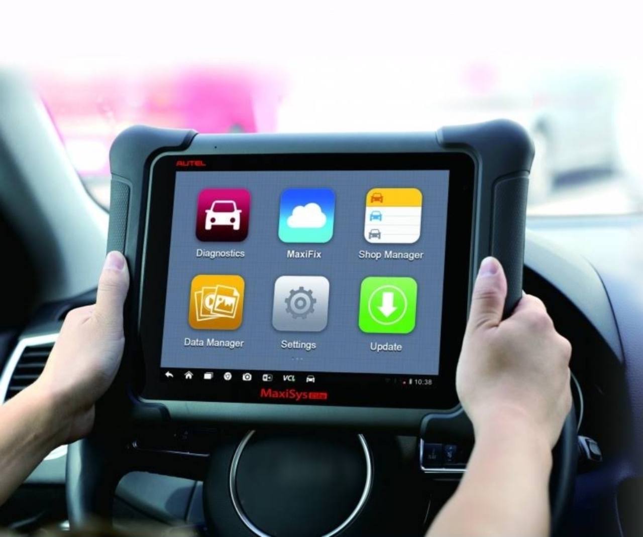Tabletă pentru diagnoză auto poziționată în fața volanului